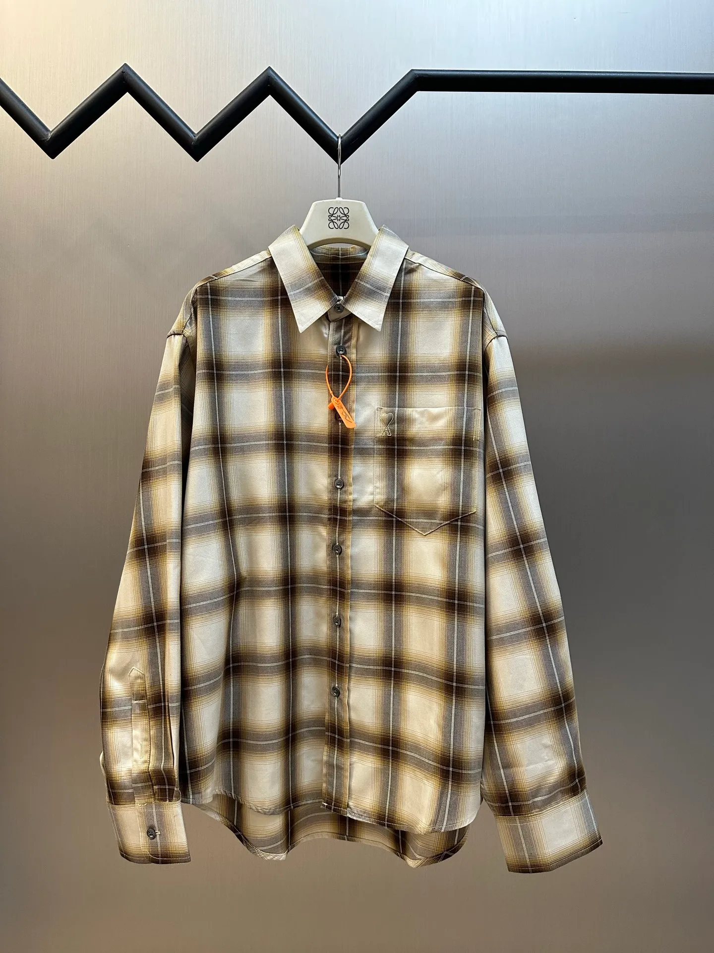 Ami Paris embroidered plaid shirt is a custom-made cloud-like Lyocell plaid Canvas, with warm brown and Cream White gradients intertwined into a mist plaid. The small chest pocket is embroidered with AMI's iconic small love heart, and the brand logo is hidden with fine stitching. It is low-key but powerful, with an undercurrent of light luxury style in the blank space, which perfectly interprets the delicate balance between French relaxation and old money style. Using imported machine embroidery technology, advanced computer control systems and precision mechanical components, Ami love embroidery operations are realized. The infrared positioning cutting machine uses an infrared transmitter and an infrared receiver to achieve precise positioning of materials. The accuracy can reach the micron level, thereby meeting the effect of high-precision cutting of plaid and strip alignment. size:38.39.40.41